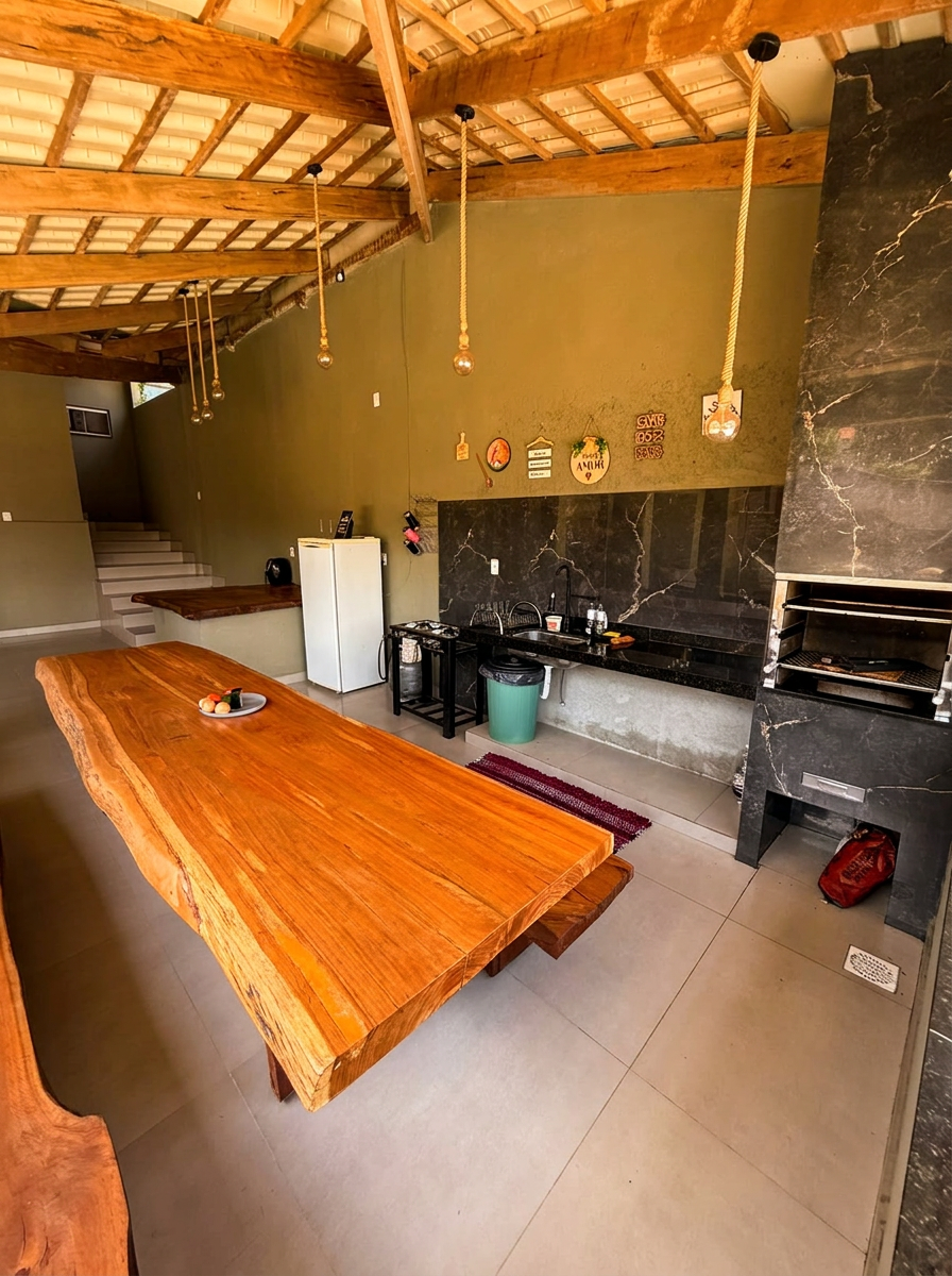 Villa Acácia — área gourmet com mesa de madeira e churrasqueira